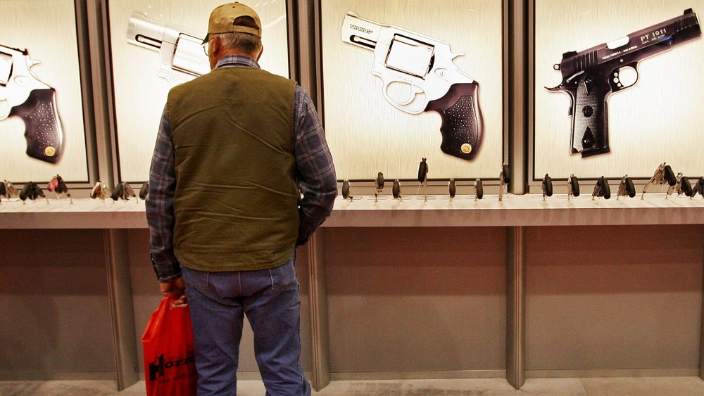A man looks over the Taurus pistol display at the NRA's annual meeting in in Louisville, Kentucky.
