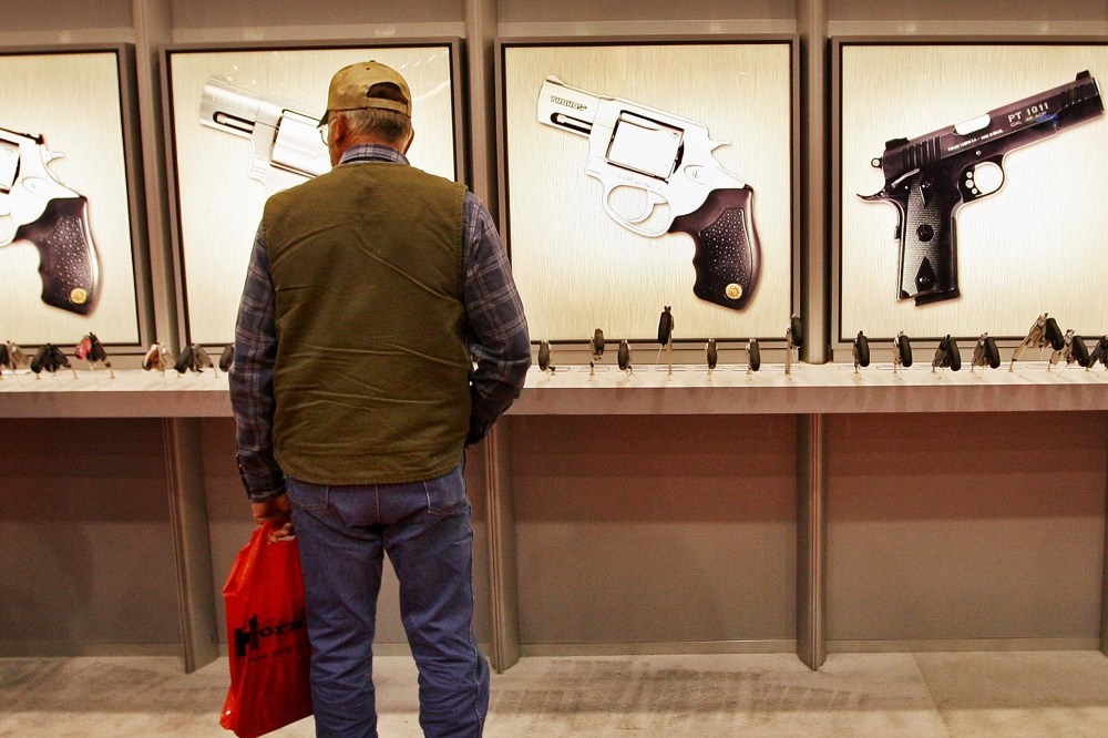 A man looks over the Taurus pistol display at the NRA's annual meeting in in Louisville, Kentucky.