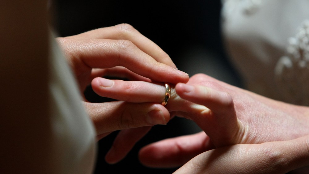 A same-sex couple exchanges rings at a wedding.