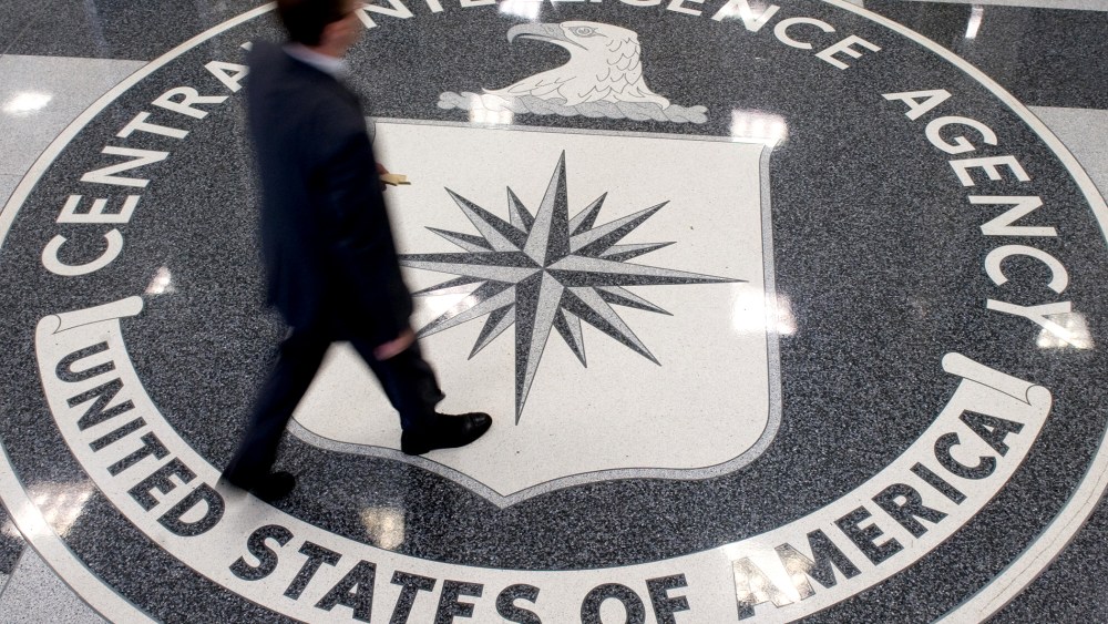 A man crosses the Central Intelligence Agency (CIA) logo in the lobby of CIA Headquarters in Langley, Virginia.