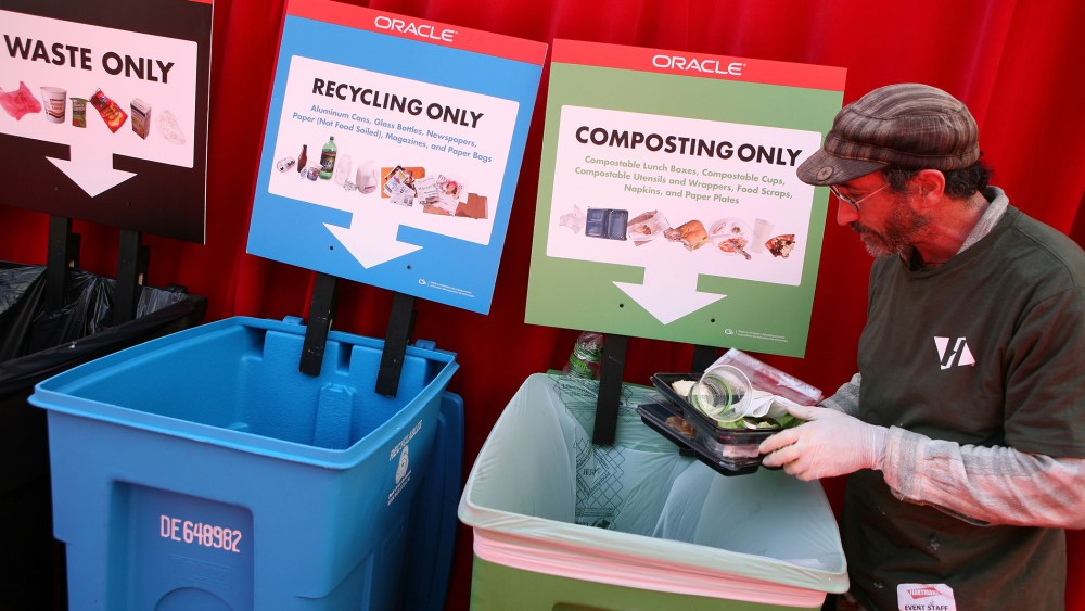 A worker separates recyclables and compost materials at the Oracle Open World conference September 22, 2008 at the Moscone Center in San Franciscso, Calif.