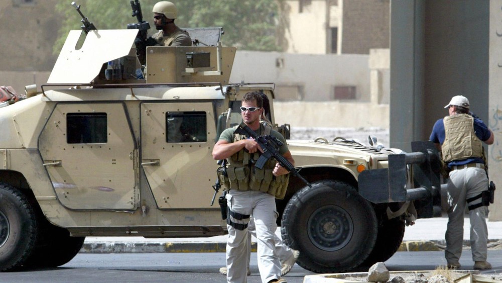 A picture taken on July 5, 2005 shows contractors of the U.S. private security firm Blackwater securing the site of a roadside bomb attack near the Iranian embassy in central Baghdad.