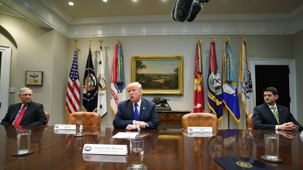U.S. President Donald Trump speaks to the media as Senate Majority Leader Mitch McConnell (L), R-KY, and Speaker of the House Paul Ryan, R-WI, look on during a meeting with congressional leadership in the Roosevelt Room at the White House on November 28,
