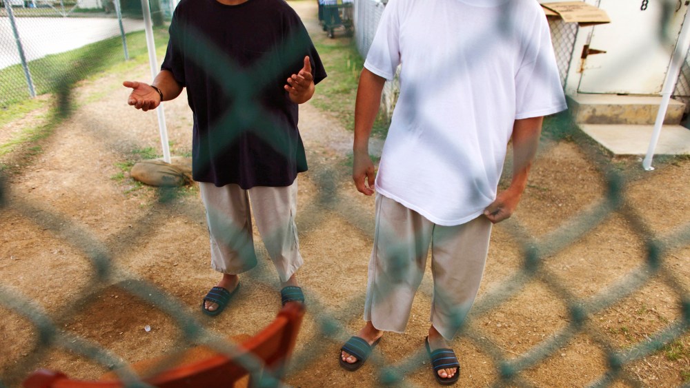 Chinese Uighur Guantanamo detainees try to talk to visiting members of the media at Camp Iguana detention facility in Guantanamo Bay, June 1, 2009.