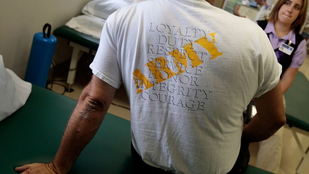 File Photo: Robert Wake (L), an Iraq war veteran suffering from posttraumatic stress disorder (PTSD), talks to physical therapist Nicole Bormann before a session in the VA Medical Center August 10, 2009 in St Louis, Missouri. Wake served in the MP ...