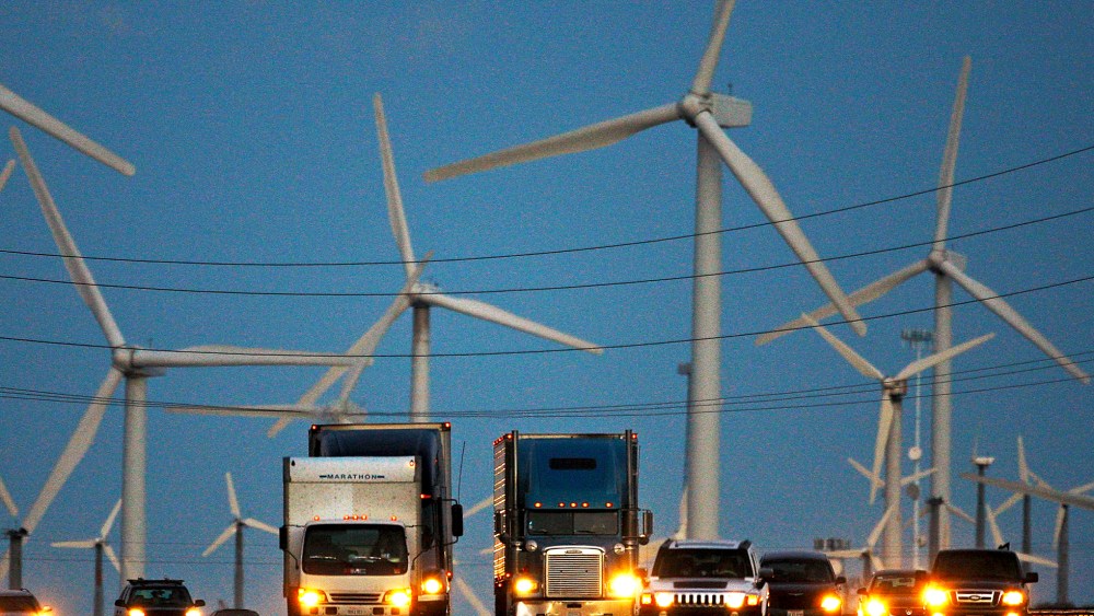 Diesel trucks and cars pass windmills along the 10 freeway near Banning, California.