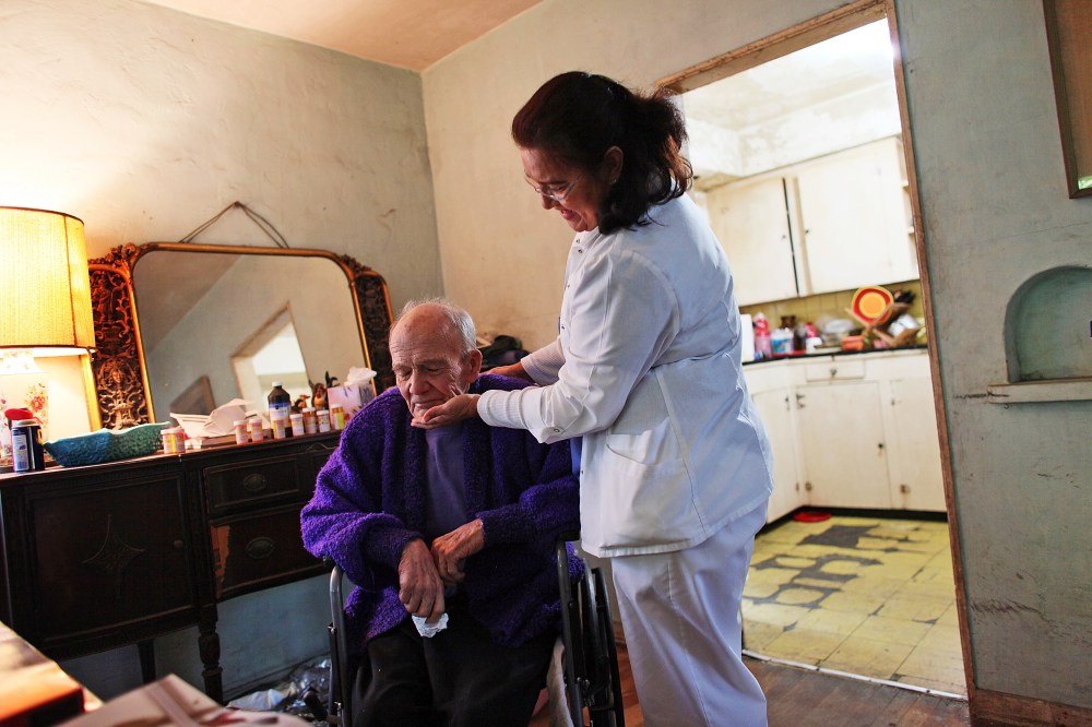 United HomeCare Services home health aide Wendy Cerrato visits with Robert Granville as she washes and feeds him in Miami, Florida.