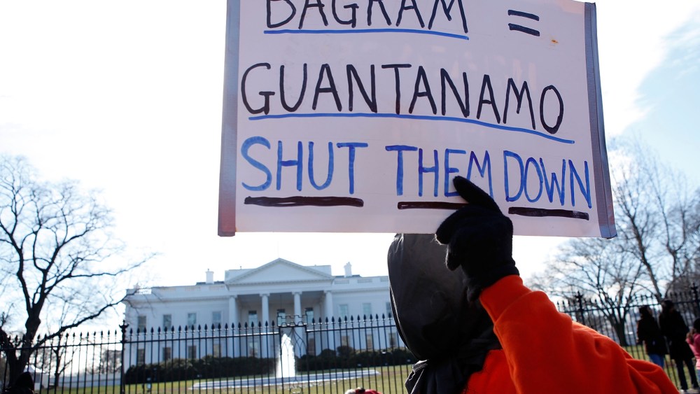 File Photo: A member of Witness Against Torture holds a sign as he protests in front of the White House to mark the eighth anniversary of the opening of Guantanamo Bay detention camp January 11, 2010 in Washington, DC. Protesters called on the Obama...