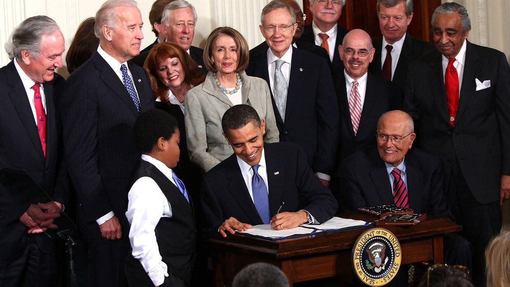 U.S. President Barack Obama signs the Affordable Health Care for America Act during a ceremony with fellow Democrats in the East Room of the White House March 23, 2010 in Washington, D.C. (Photo by Win McNamee/Getty)