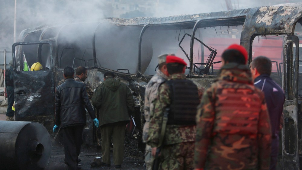 Afghan security guards inspect a damaged bus at the site of a suicide attack by the Taliban in Kabul, Afghanistan on Dec. 13, 2014. (Rahmat Gul/AP)