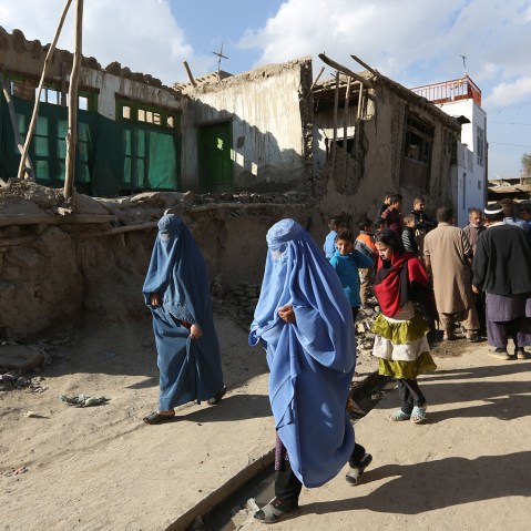 Afghan women walk towards a damaged house following an earthquake, in Kabul, Afghanistan, Oct. 26, 2015. (Photo by Rahmat Gul/AP)