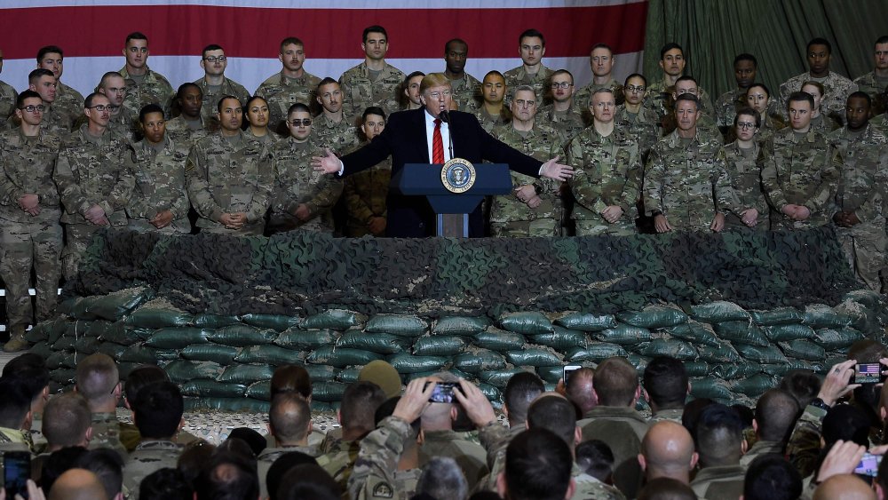 In this file photo taken on November 28, 2019 US President Donald Trump speaks to the troops during a surprise Thanksgiving day visit at Bagram Air Field, in Afghanistan.