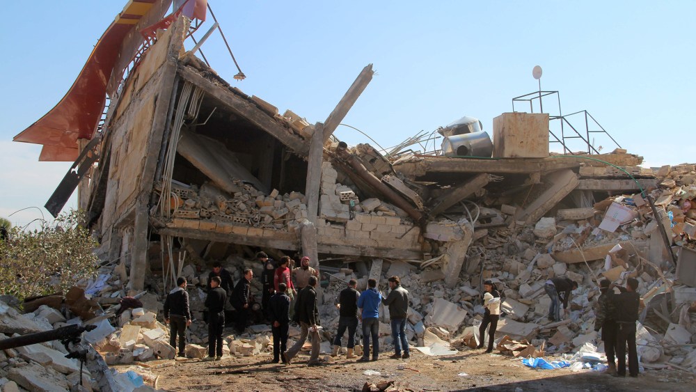 People gather around the rubble of a hospital supported by Doctors Without Borders (MSF) near Maaret al-Numan, in Syria's northern province of Idlib, on Feb. 15, 2016. (Photo by Ghaith Omran/AFP/Getty)