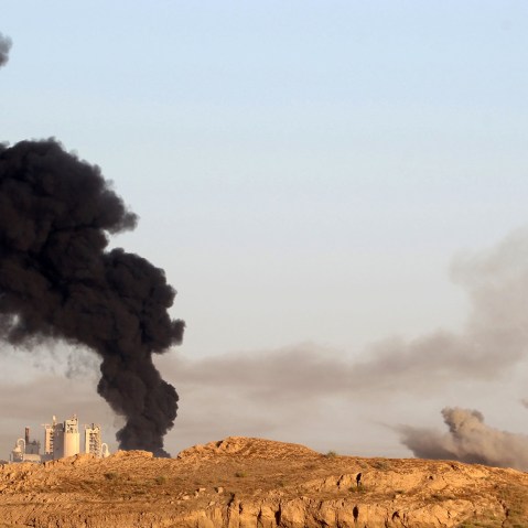 Smoke billows in the background as Iraqi pro-government forces advance towards the city of Fallujah on May 23, 2016, as part of a major assault to retake the city from Islamic State (IS) group. (Photo by Ahmad Al-Rubaye/AFP/Getty)