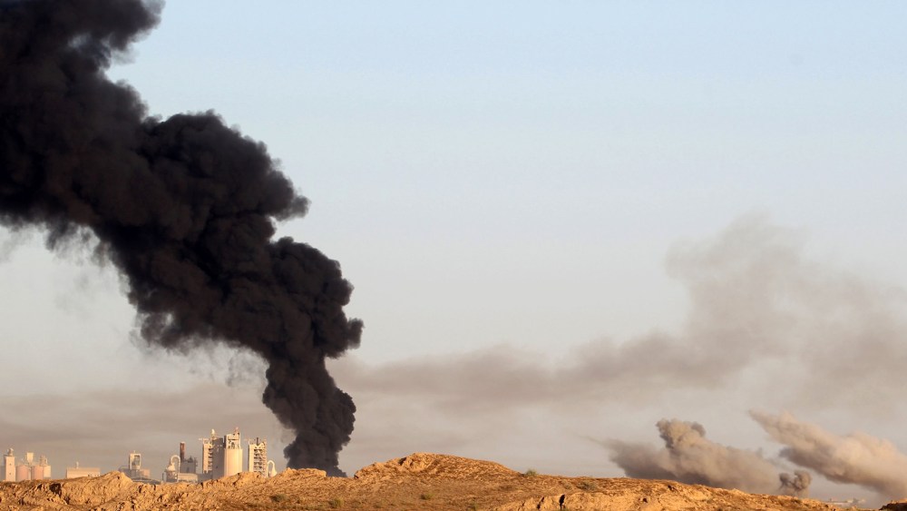 Smoke billows in the background as Iraqi pro-government forces advance towards the city of Fallujah on May 23, 2016, as part of a major assault to retake the city from Islamic State (IS) group. (Photo by Ahmad Al-Rubaye/AFP/Getty)
