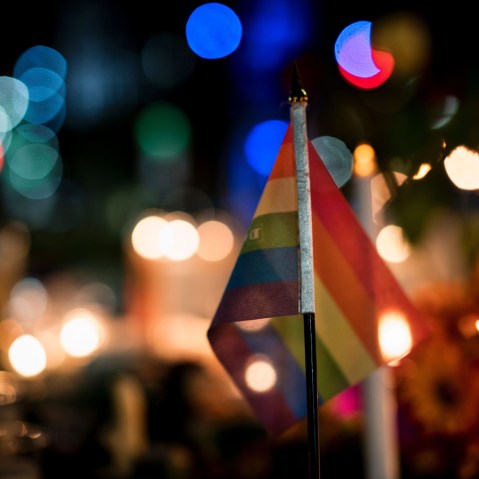 A gay pride flag is seen at a memorial after a vigil outside the Dr. Phillips Center for the Performing Arts for the mass shooting victims at the Pulse nightclub June 13, 2016 in Orlando, Fla. (Photo by Brendan Smialowski/AFP/Getty)