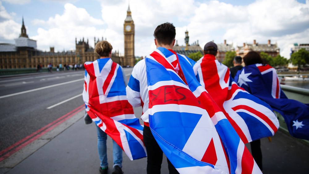 People walk over Westminster Bridge towards the Queen Elizabeth Tower (Big Ben) and The Houses of Parliament wrapped in Union flags on June 26, 2016 in central London. (Photo by Odd Andersen/AFP/Getty)