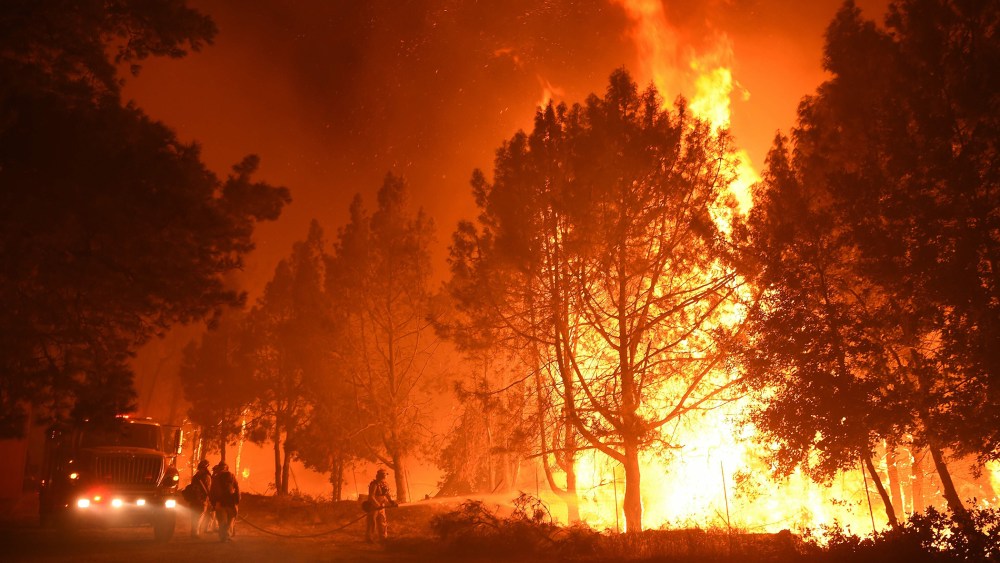 Firefighters douse flames as they approach the Casa Loma fire station in the Santa Cruz Mountains near Loma Prieta, Calif. on Sept. 27, 2016. (Photo by Josh Edelson/AFP/Getty)