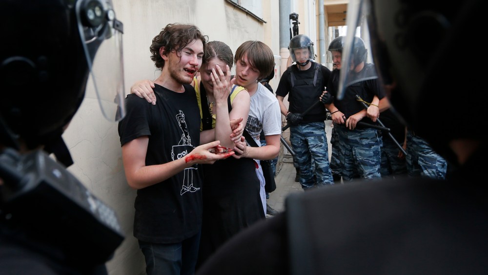 Riot police guard gay rights activists who were beaten by anti-gay protesters at an authorized gay rights rally in St. Petersburg, Russia on June 29, 2013