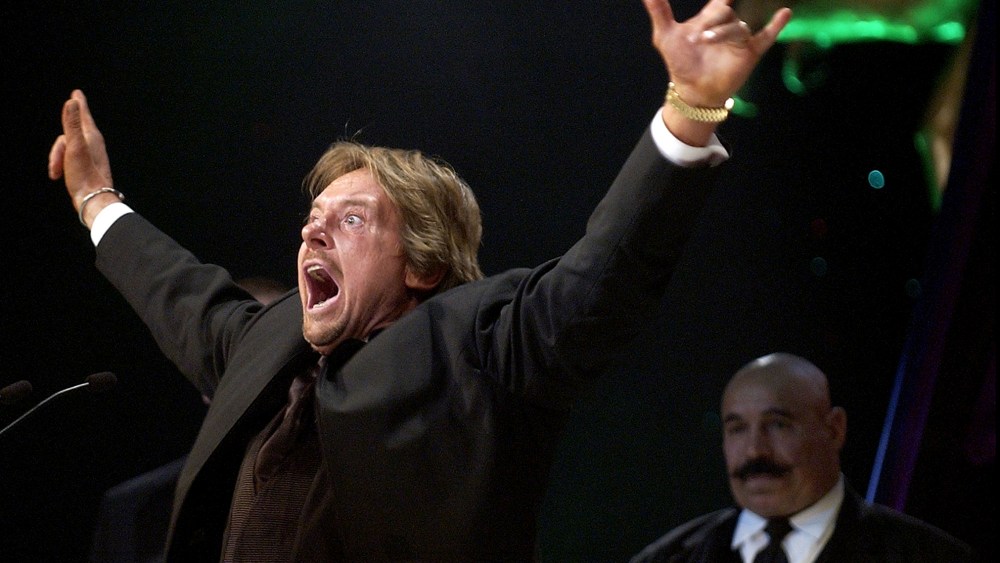 Wrestler Rowdy Roddy Piper gestures to the crowd as wrestler The Iron Sheik looks on after being inducted into the WWE Hall of Fame at the Induction Ceremony in Universal City, Calif., April 2, 2005. (Photo by Matt Sayles/AP)