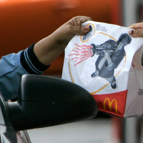 An employee hands a drive-thru order to a McDonald's customer at the Rock & Roll McDonalds in Chicago on Oct. 15, 2007. (Photo by M. Spencer Green/Getty)