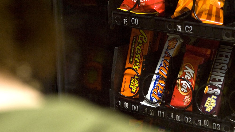 A stutdent stands in front of a vending machine in Charleston, W.Va.
