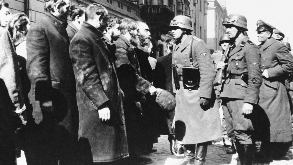 Nazi officers talk with citizens of the Warsaw ghetto, Poland, spring 1943. (Photo by AP)