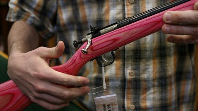 Sales associate David Jarasiewicz explains the single bolt action as he shows a pink .22 caliber youth model rifle in the gun department of the Sportsman's Warehouse in Ben Avon, Pa., Tuesday, March 3, 2009. (Photo by Keith Srakocic/AP)