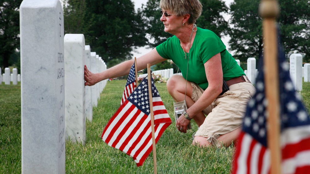 Anita Dixon, of Wichita, Kan., whose son Army Sgt. Evan Parker was killed while serving in Iraq in 2005, touches a grave in Arlington National Cemetery.
