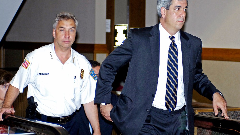 Buffalo Police Commissioner Daniel Derenda, left, and Erie County District Attorney Frank Sedita travel the escalator to the courtroom for proceedings in Buffalo, N.Y., 2010.