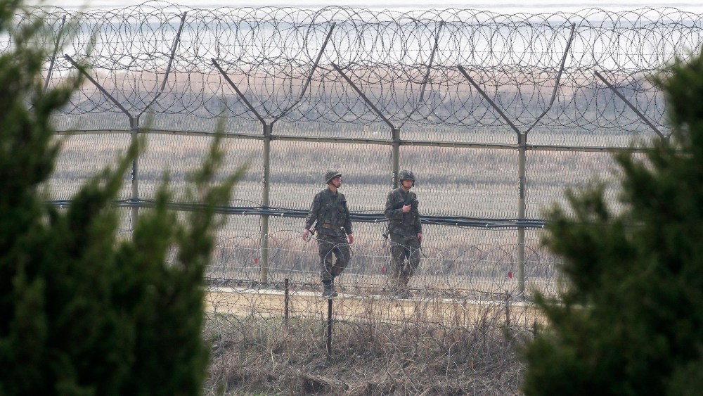 South Korean army soldiers patrol along a barbed-wire fence in Paju, near the border with North Korea, South Korea, March 27, 2014.
