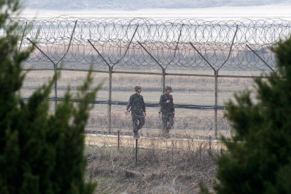 South Korean army soldiers patrol along a barbed-wire fence in Paju, near the border with North Korea, South Korea, March 27, 2014.