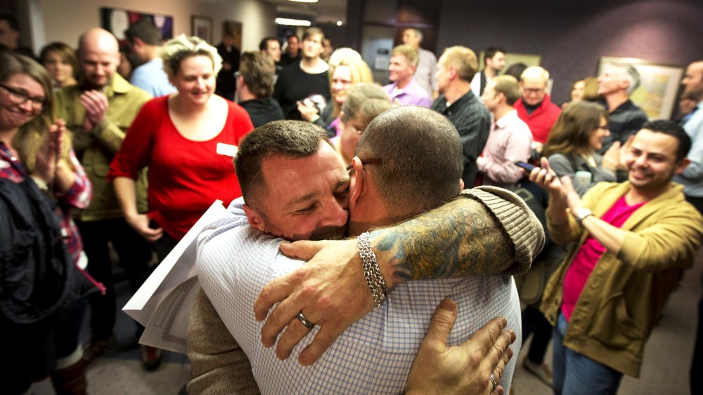Image: Chris Serrano, left, and Clifton Webb embrace after being married, as people wait in line to get licenses outside of the marriage division of the Salt Lake County Clerk's Office in Salt Lake City, Friday, Dec. 20, 2013