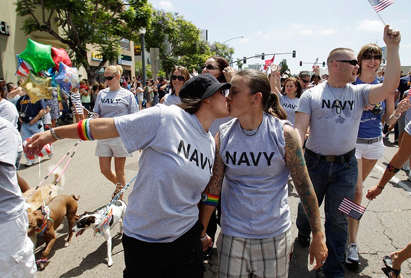 In this July 16,2011 photo, two women, both active duty sailors in the Navy who gave their names as Nikki, left, and Lisa, kiss as they march in the Gay Pride Parade in San Diego. (Photo by Gregory Bull/AP)