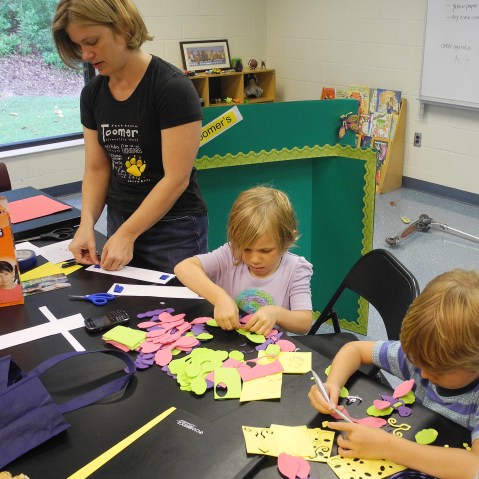 File Photo:  Parent volunteer Trinity Laurino, left, works on bulletin board decorations at Toomer Elementary School in Atlanta with her daughter, Olivia Laurino, center, and friend, Jake Jonsson in Atlanta. Atlanta Public Schools returns to classes...