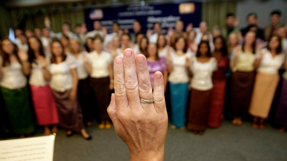 U.S. Peace Corps volunteers raise their hands to swear in during a ceremony in Phnom Penh, Cambodia, on Oct. 3, 2011.