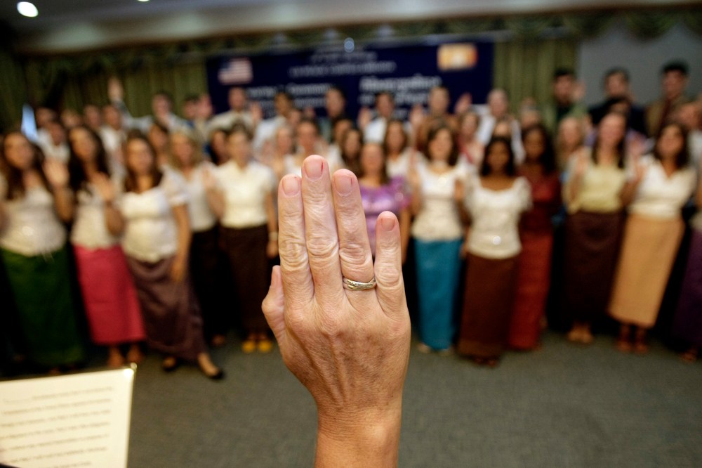 U.S. Peace Corps volunteers raise their hands to swear in during a ceremony in Phnom Penh, Cambodia, on Oct. 3, 2011.