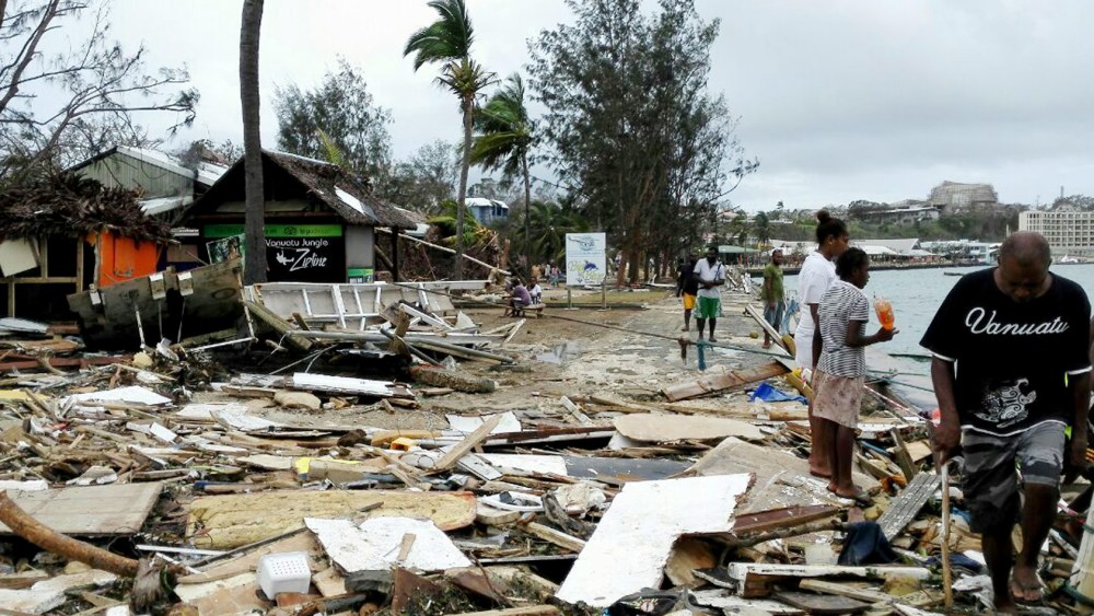 In this photo provided by China's Xinhua News Agency, locals walk past debris in Port Vila, Vanuatu, after Cyclone Pam ripped through the tiny South Pacific archipelago, March 15, 2015. (Photo by Luo Xiangfeng/Xinhua via AP)