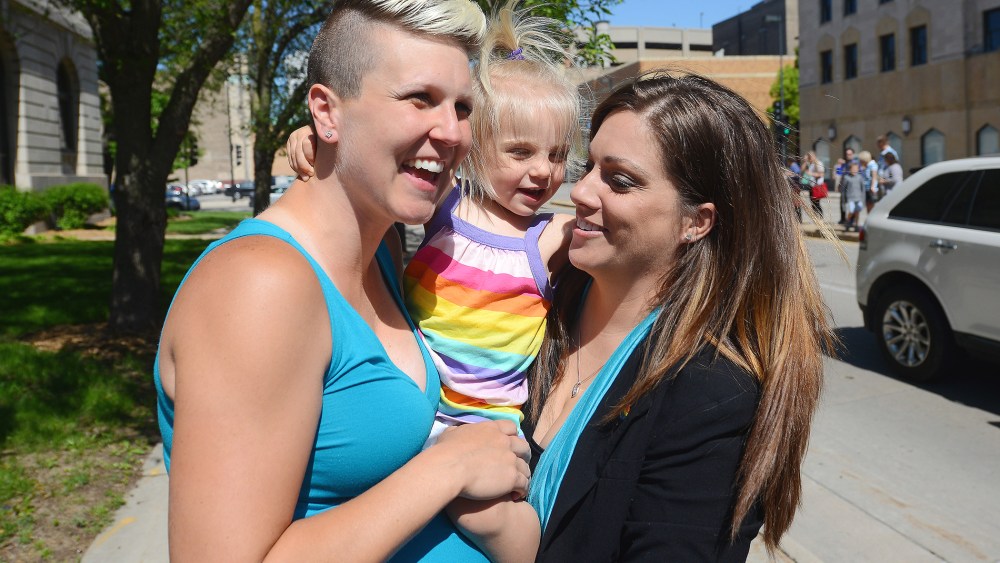 Berri West, left, and new spouse Lisa West, right, hold their daughter Sylas just before they were married Monday, June 9, 2014, after the Brown County Clerk's office began issuing marriage licenses to same sex couples.