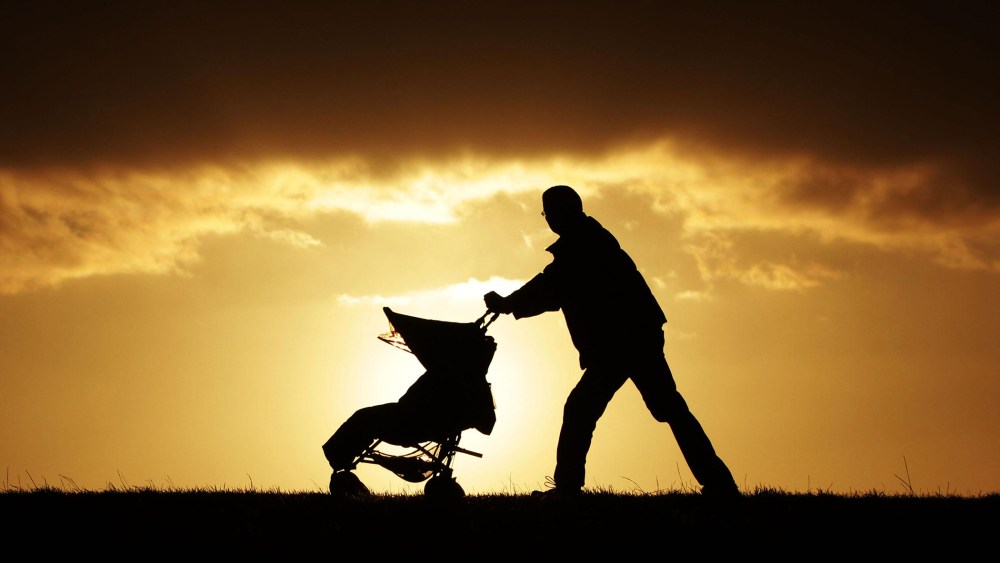 A man pushes a stroller in London, U.K., Nov. 27, 2011. (Photo by Yui Mok/PA Wire/AP)