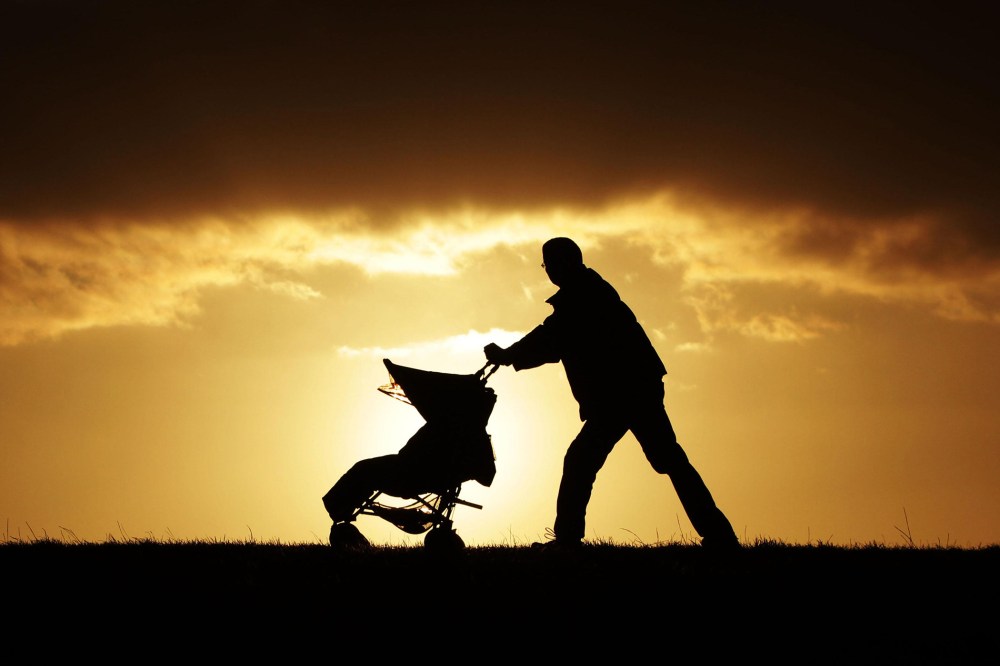 A man pushes a stroller in London, U.K., Nov. 27, 2011. (Photo by Yui Mok/PA Wire/AP)