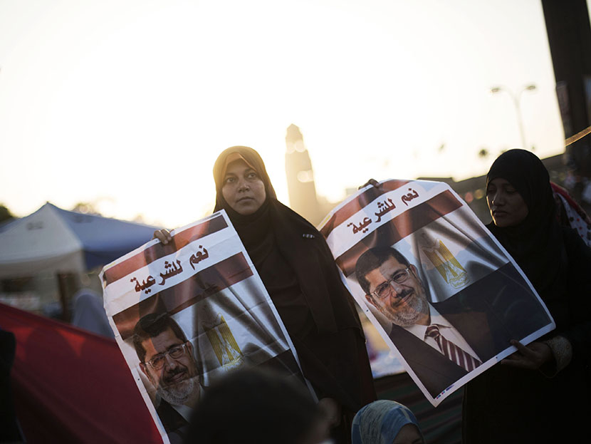 A woman supporter of Egypt's ousted President Mohammed Morsi holds a banner of the former president  with Arabic that reads "yes to legitimacy," during a protest near Cairo University in Giza, Egypt, Thursday, August, 1, 2013. (Photo by Manu Brabo/AP)