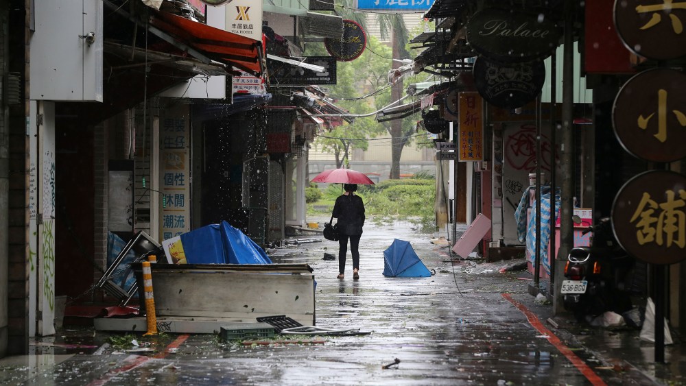 A woman walks down a back alley filled with debris from Typhoon Soudelor in Taipei, Taiwan, Aug. 8, 2015, after Soudelor brought heavy rains and strong winds to the island. (Photo by Wally Santana/AP)
