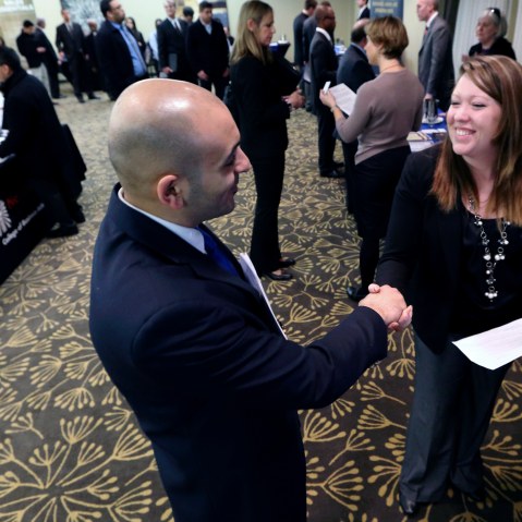In this Monday, Feb. 25, 2013, photo, Sayed Mouawad, left, of Providence, R.I., shakes hands with Jillian Wallace of Matix, Inc., during a job fair in Boston. The number of people seeking U.S. unemployment aid fell to a seasonally adjusted 340,000 in...