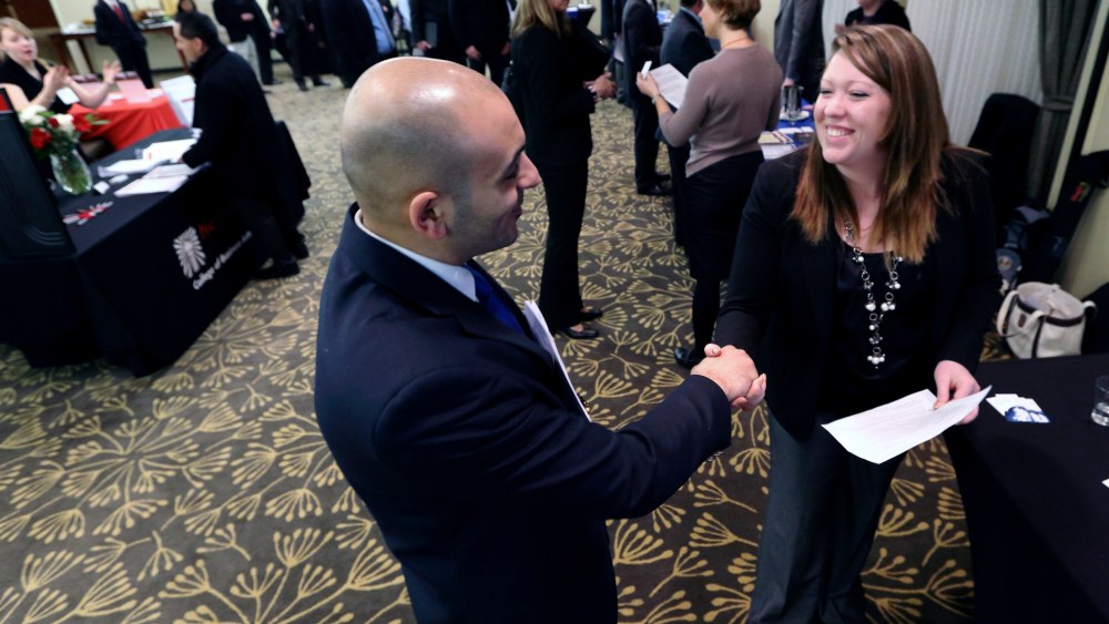In this Monday, Feb. 25, 2013, photo, Sayed Mouawad, left, of Providence, R.I., shakes hands with Jillian Wallace of Matix, Inc., during a job fair in Boston. The number of people seeking U.S. unemployment aid fell to a seasonally adjusted 340,000 in...