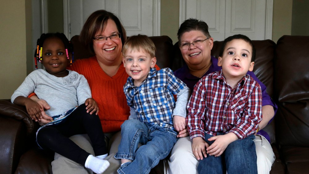 April DeBoer, second from left, sits with her adopted daughter Ryanne, 3, left, and Jayne Rowse, fourth from left, and her adopted sons  Jacob, 3, middle, and Nolan, 4, right, at their home in Hazel Park, Tuesday, March 5, 2013. (AP Photo/Paul Sancya)