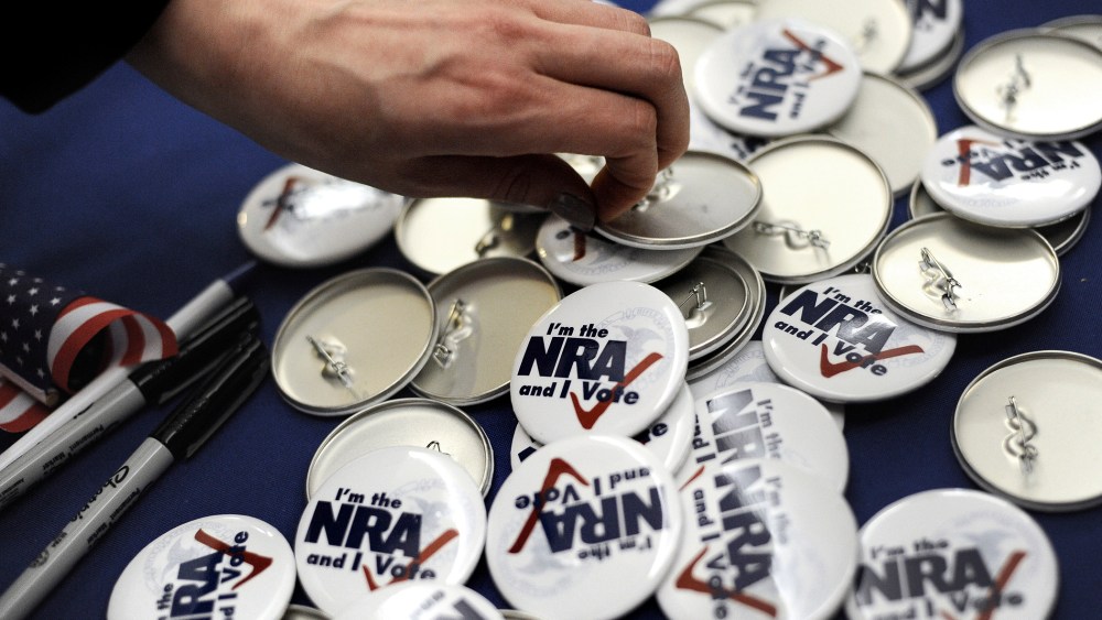 A woman grabs a button during a "lobby day" held by the National Rifle Association and other gun rights groups at the Legislative Office Building in Hartford, Conn., Monday, March 11, 2013.