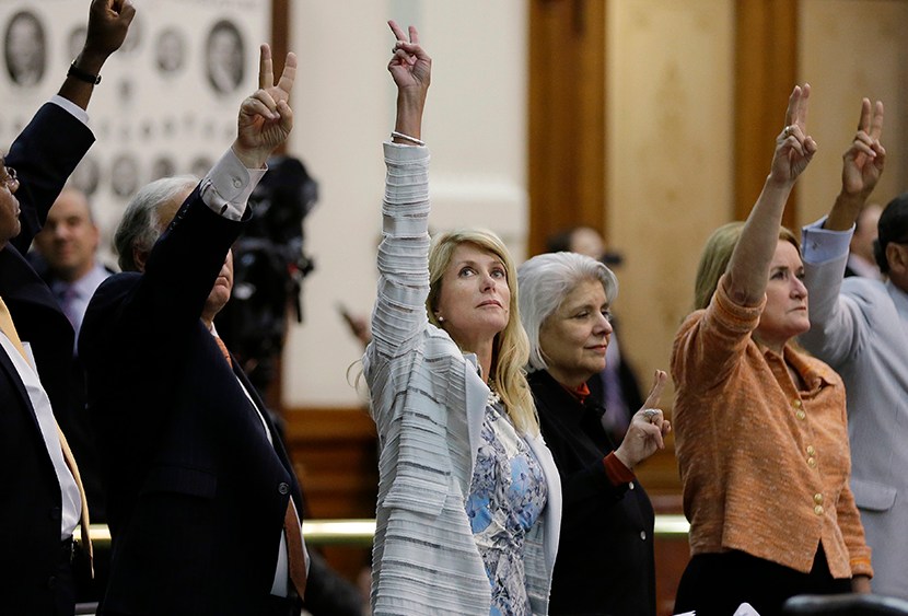 Sen. Wendy Davis, D-Fort Worth, center, holds up two fingers to signal a no vote as the session where they tried to filibuster an abortion bill draws to a close, Tuesday, June 25, 2013, in Austin, Texas.   (Photo by Eric Gay/AP)