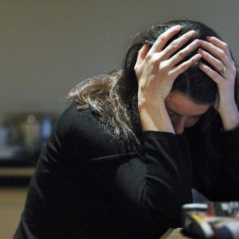 A posed woman with her head in her hands for a domestic violence awareness campaign. (Photo by David Cheskin/PA Wire/AP)