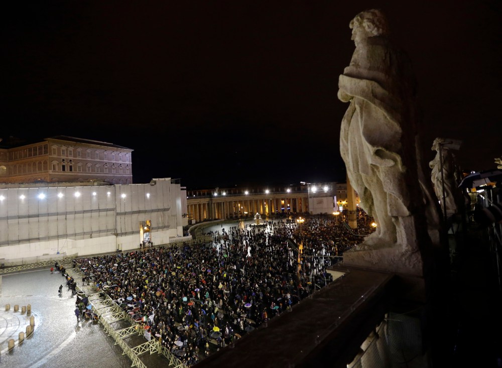 People gather in St. Peter's Square at the Vatican, Tuesday, March 12, 2013. Cardinals from around the globe locked themselves inside the Sistine Chapel on Tuesday to choose a new leader for the world's 1.2 billion Catholics and their troubled church. ...
